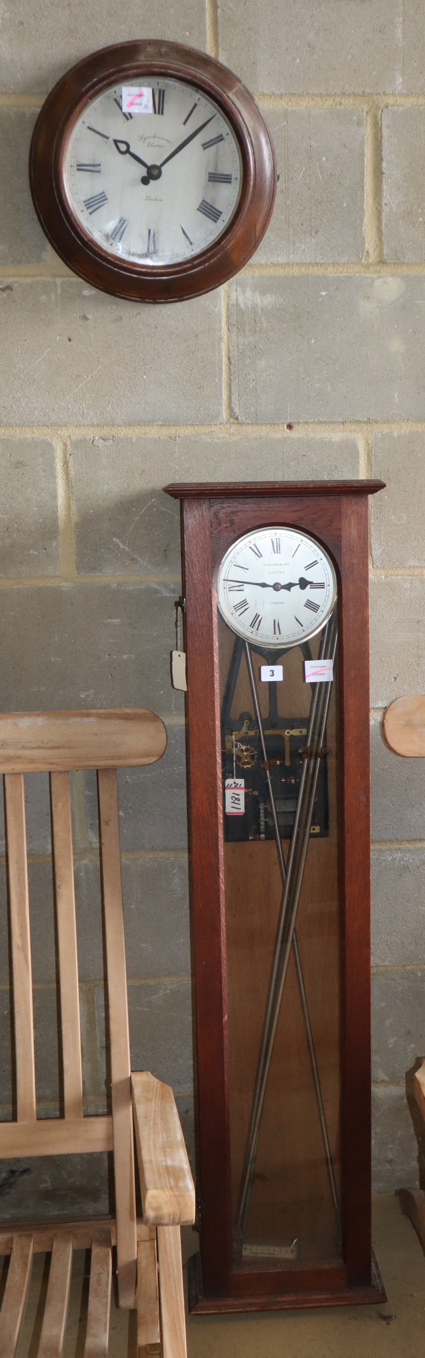 A Synchronome electric master clock in an oak case, Dial 35cm diameter, H.129cm, together with a similar circular slave clock